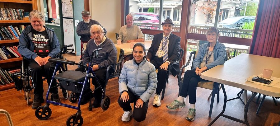 Physiotherapist supporting an older adult during a gentle mobility session